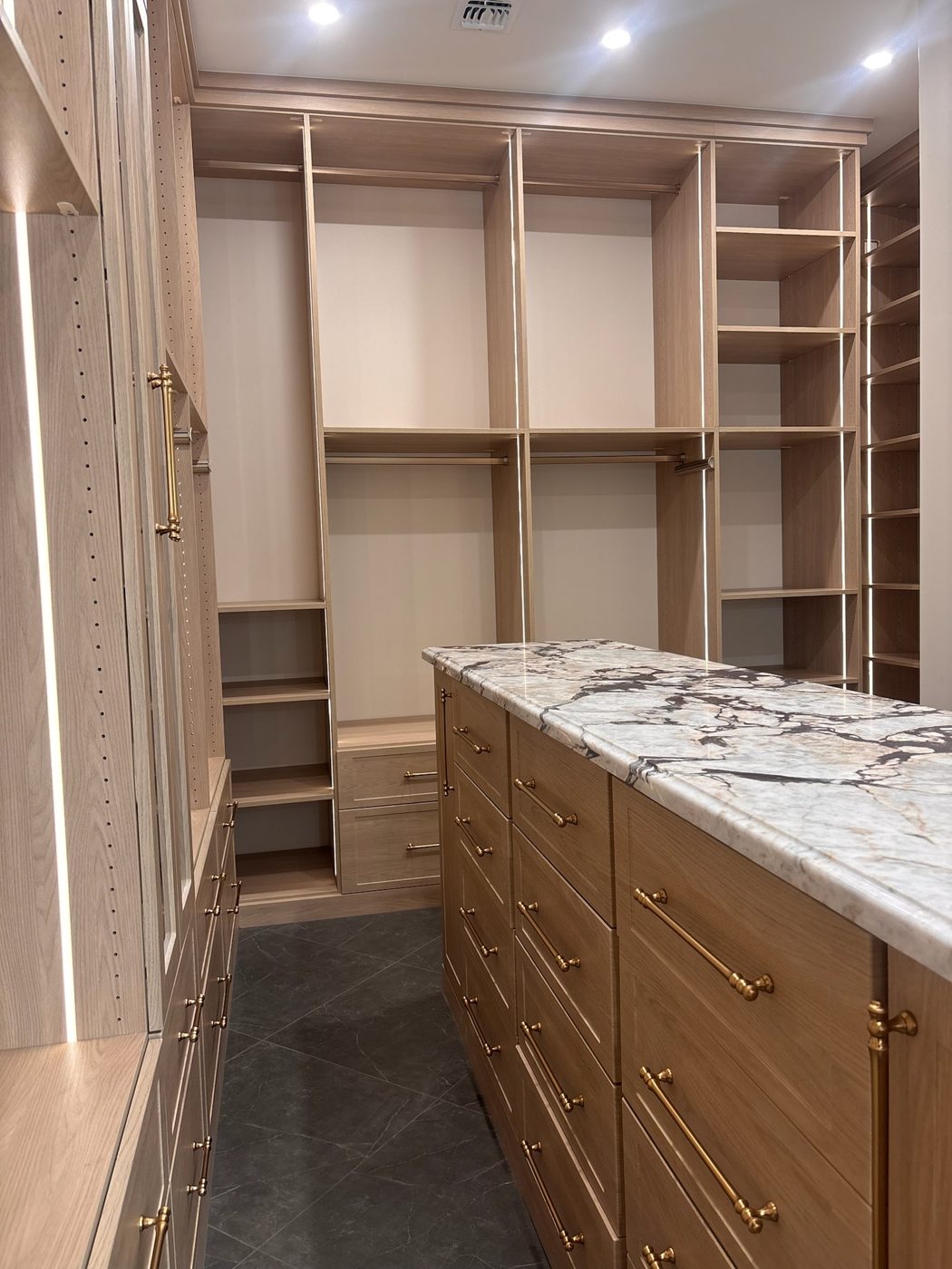 Long walk-in closet with center island drawers