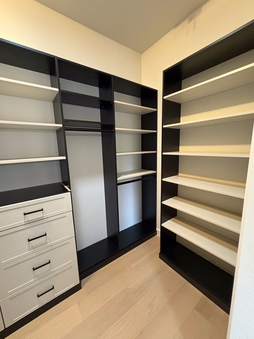 White walk-in closet with black accent panels